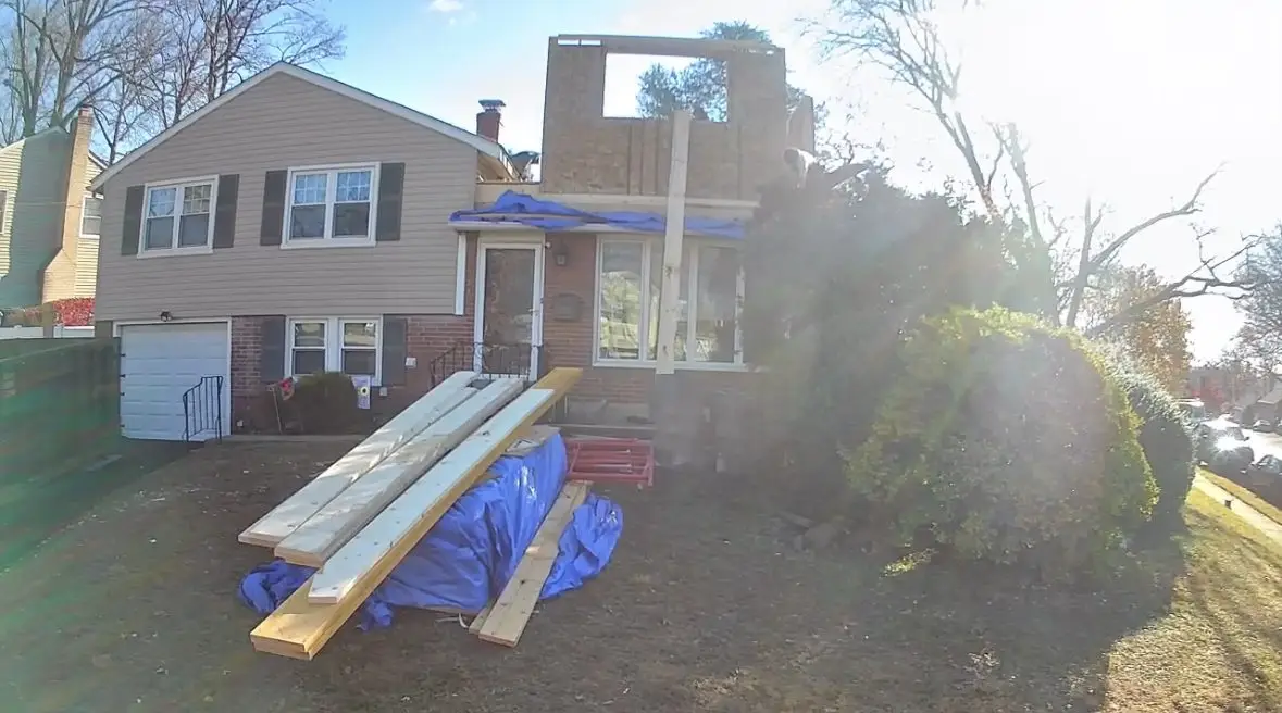 Lumber stacked on the front lawn in Abington, PA while our crew frames the new third story above