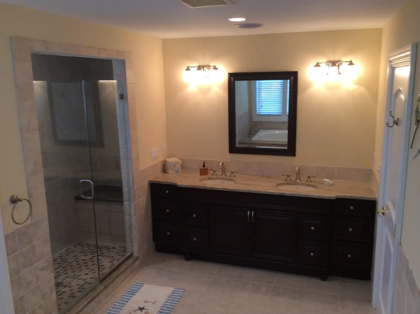 Bath in the Ocean City, NJ beach house with a dark double vanity and a glass-doored shower