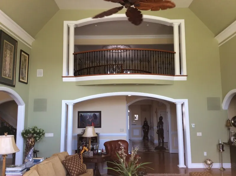 Two-story great room with an interior balcony above arched openings